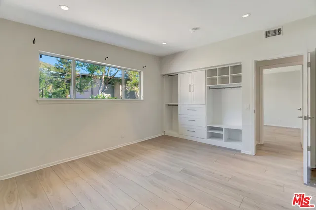 a front view of a house with a yard and potted plants