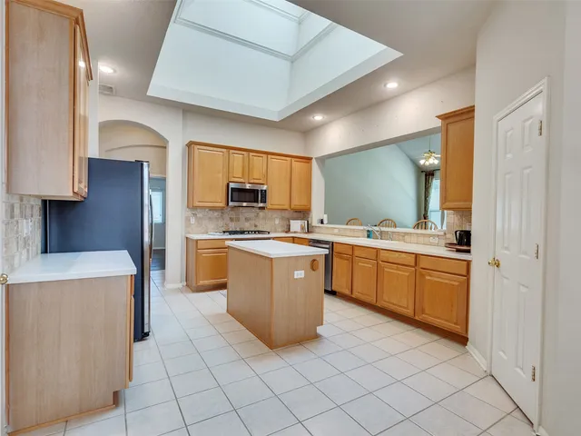 a kitchen with stainless steel appliances cabinets and wooden floor