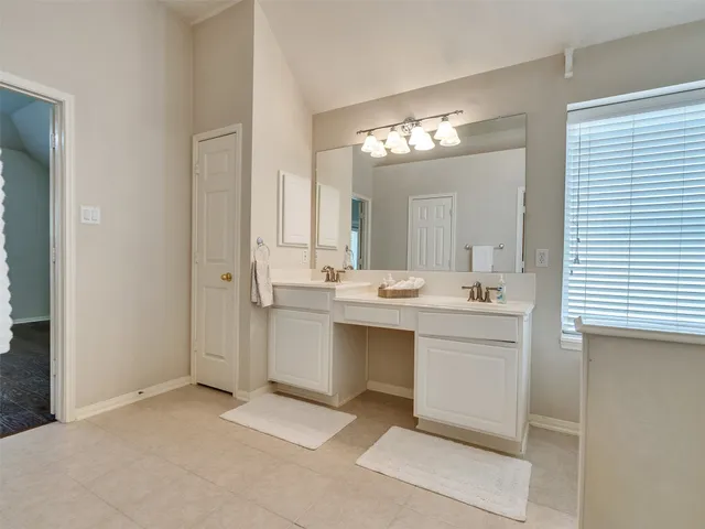 a view of an empty room with wooden floor and a ceiling fan