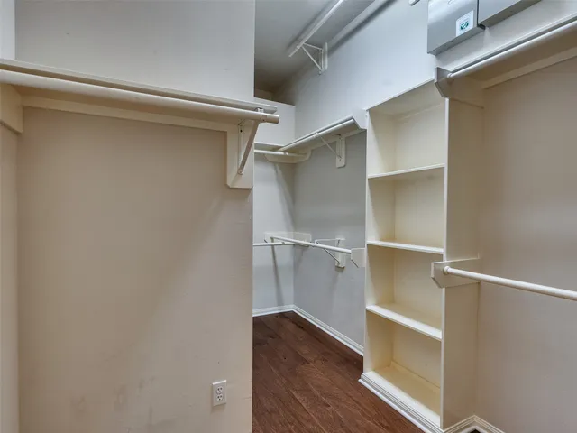 a backyard of a house with plants and large tree