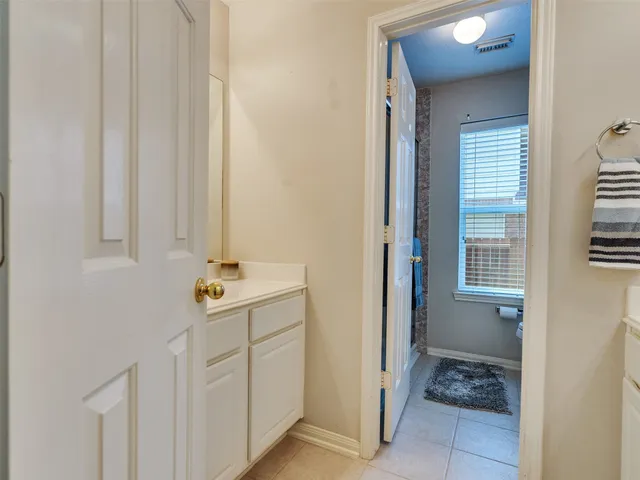 a view of a backyard with table and chairs plants and large tree