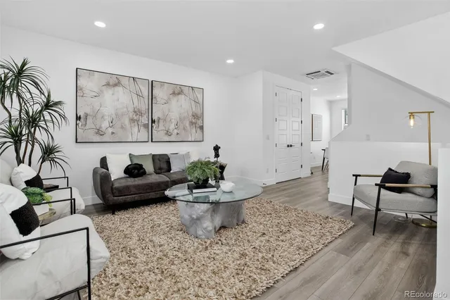 a living room with furniture and wooden floor