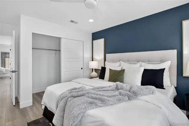 a bedroom with a bed a table and painting on the wall