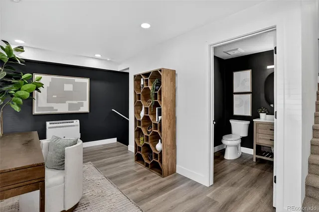 a living room with stainless steel appliances kitchen island granite countertop furniture and a wooden floor
