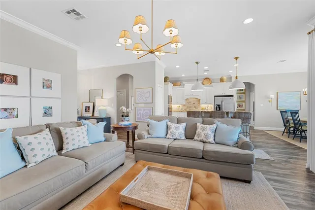 a living room with furniture and a chandelier