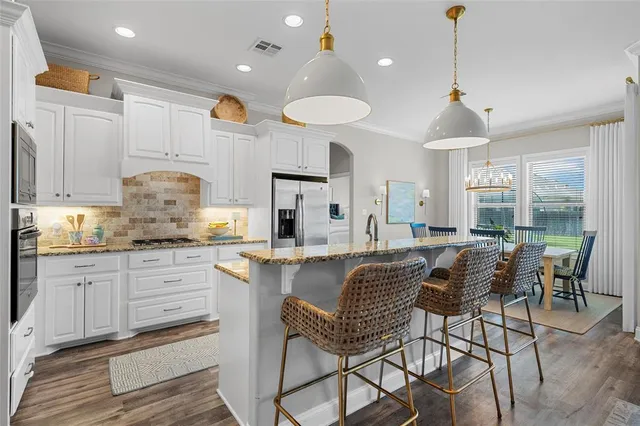 a kitchen with kitchen island granite countertop a table and chairs in it