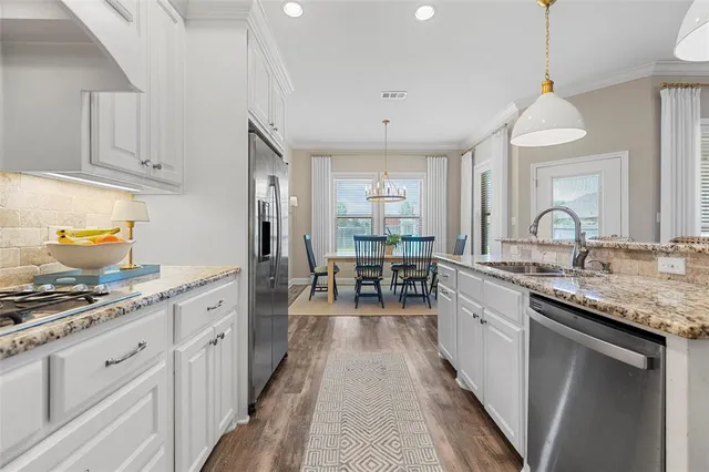 a kitchen with sink stove and cabinets