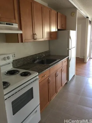 a kitchen with granite countertop white cabinets and white appliances