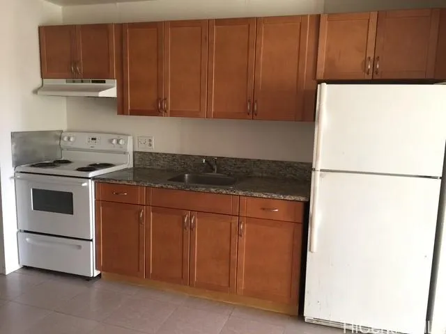 a kitchen with stainless steel appliances granite countertop a stove a refrigerator and a cabinets with wooden floor