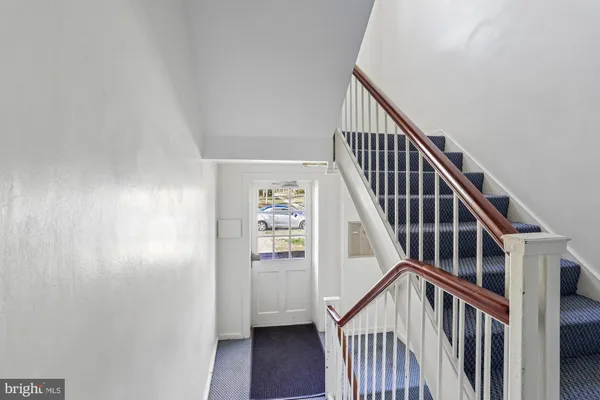 a view of staircase with wooden floor and white walls