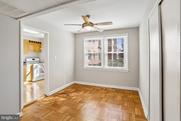 a view of empty room with wooden floor and fan