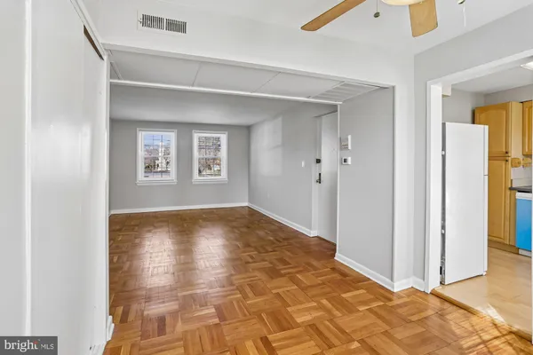 a view of empty room with window and wooden floor