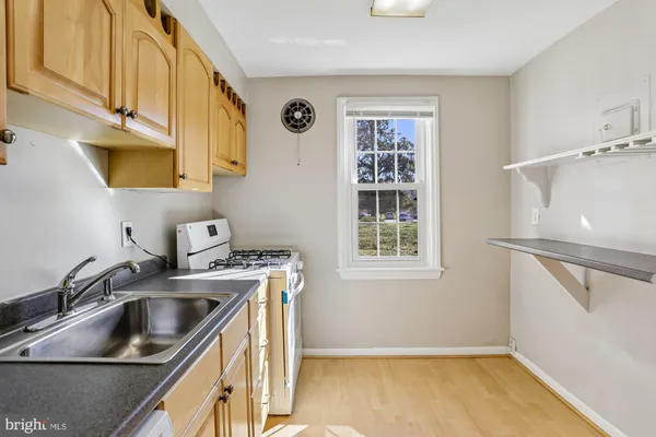 a kitchen that has a sink a stove and a window