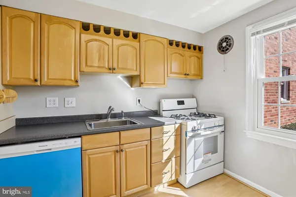a kitchen with stainless steel appliances granite countertop a sink and a stove next to a window