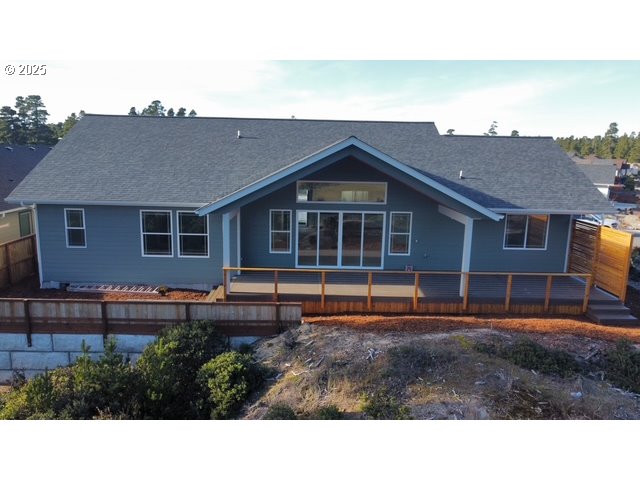 560 Tournament Drive Florence, OR 97439 - Photo 3 of 7 a backyard of a house with wooden deck and outdoor seating