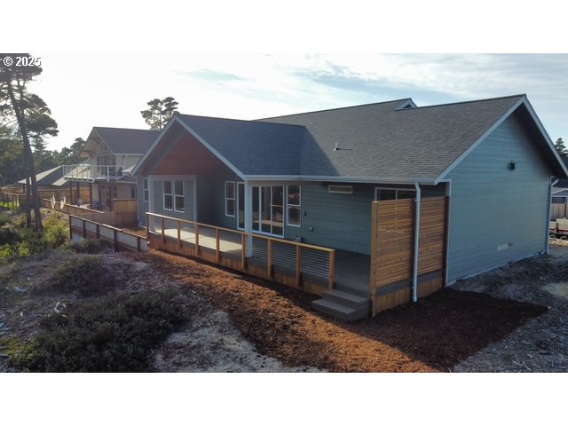 560 Tournament Drive Florence, OR 97439 - Photo 4 of 7 a black and white building in front of a big yard