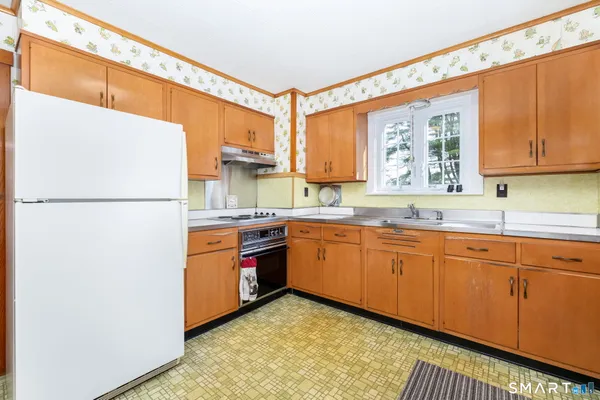 a kitchen with stainless steel appliances granite countertop a refrigerator a sink dishwasher a stove with wooden cabinets