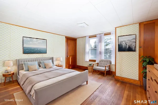 a bedroom with a bed and wooden floor