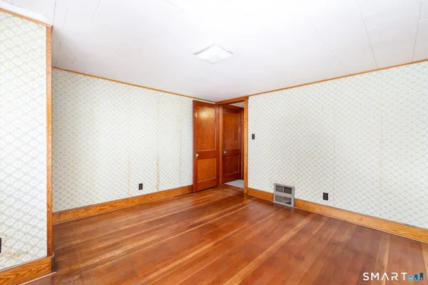 a view of an empty room with wooden floor