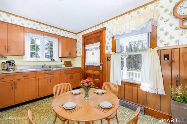 a open kitchen with stainless steel appliances granite countertop a stove a dining table and chairs next to a window