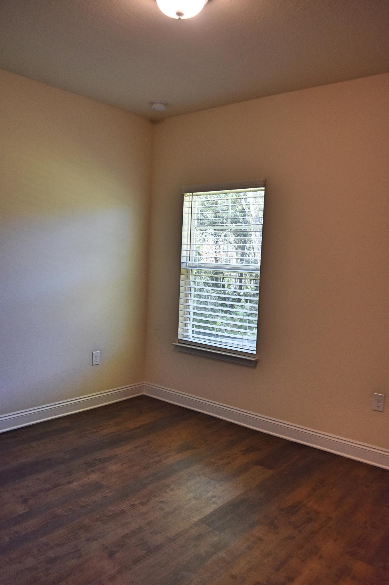 211 Brandywine Road Freeport, FL 32439 - Photo 17 of 37 a view of an empty room with wooden floor and a window