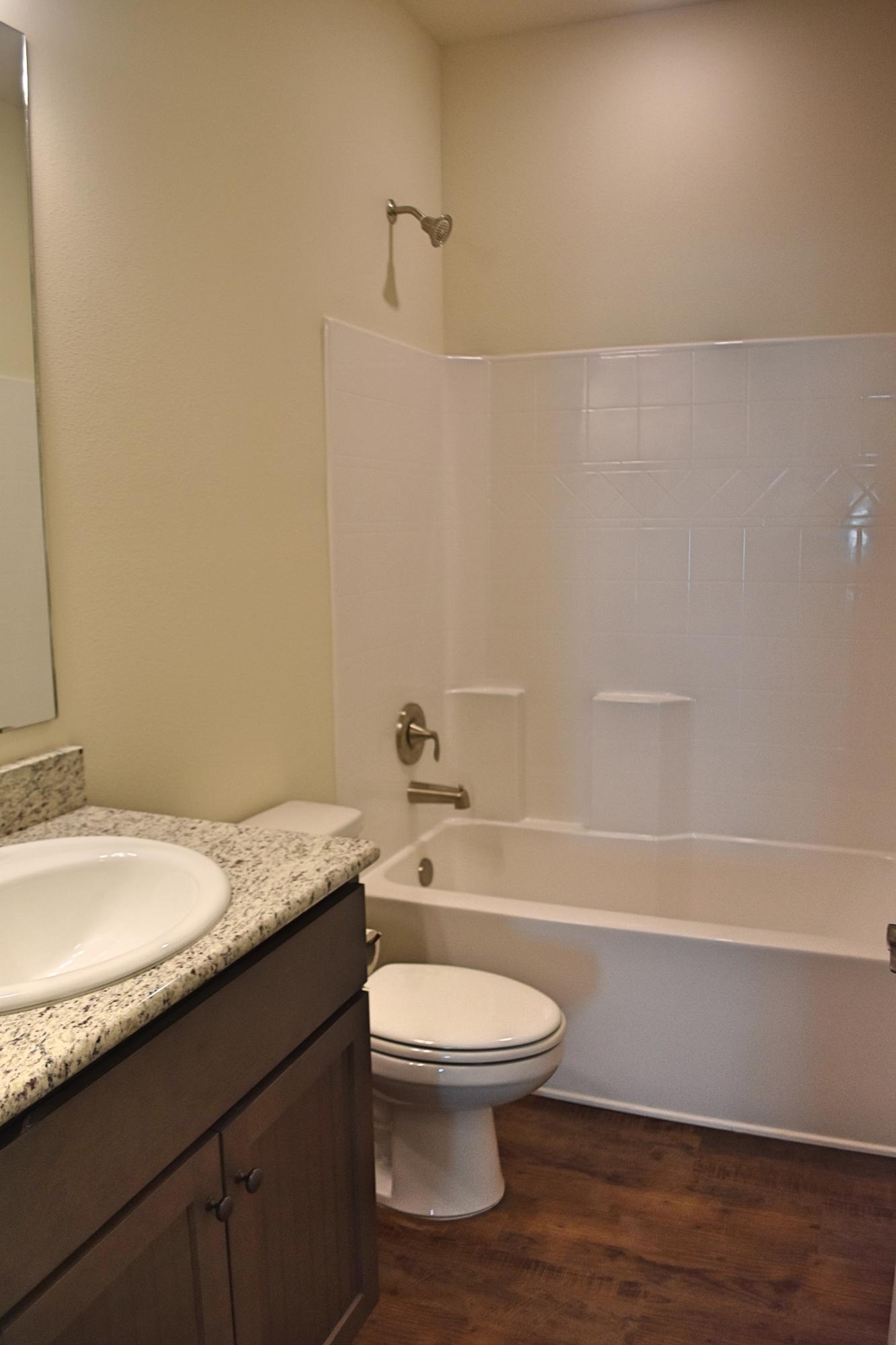 211 Brandywine Road Freeport, FL 32439 - Photo 20 of 37 a bathroom with a granite countertop toilet a sink and bathtub