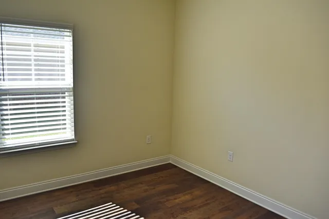 a view of a small space with wooden floor and a window