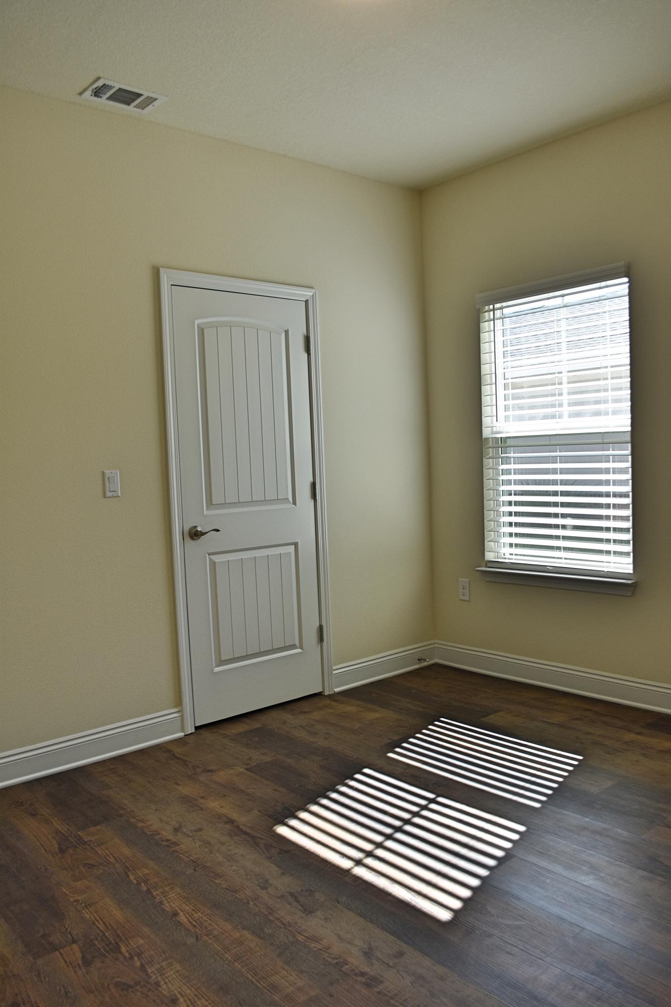 211 Brandywine Road Freeport, FL 32439 - Photo 24 of 37 an empty room with wooden floor a rug and a window