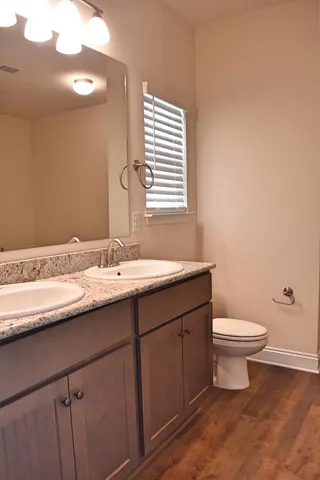a bathroom with a sink a toilet and a mirror