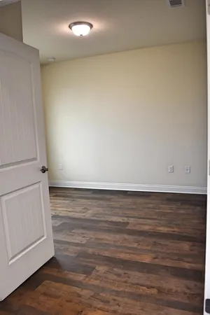 a view of an empty room and wooden floor