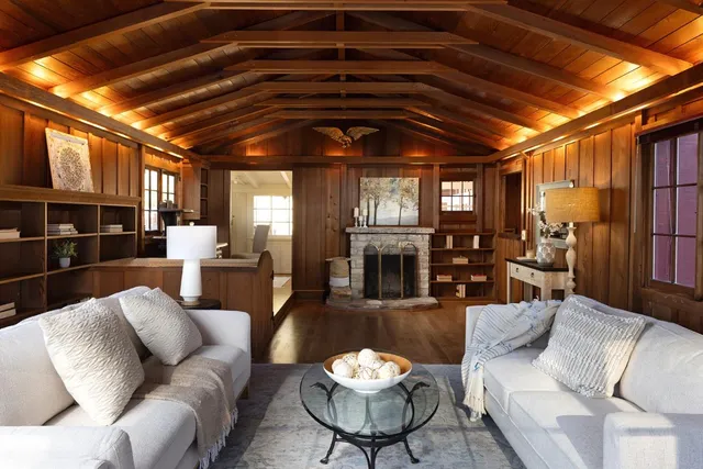 a living room with furniture a fireplace and a chandelier
