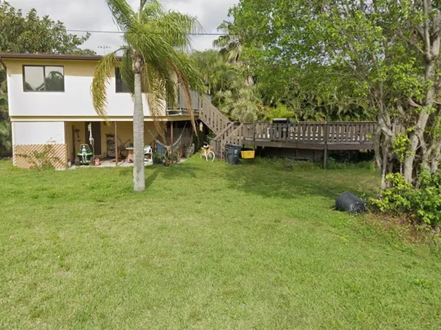 a view of a house with backyard and sitting area