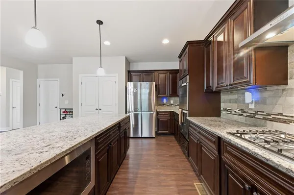 a kitchen with stainless steel appliances granite countertop a stove a sink and a refrigerator