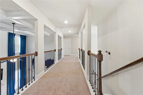 a view of a hallway with wooden floor and staircase