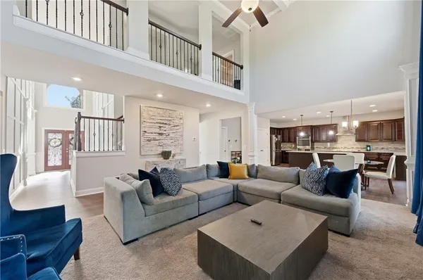 a living room with furniture kitchen view and a large window