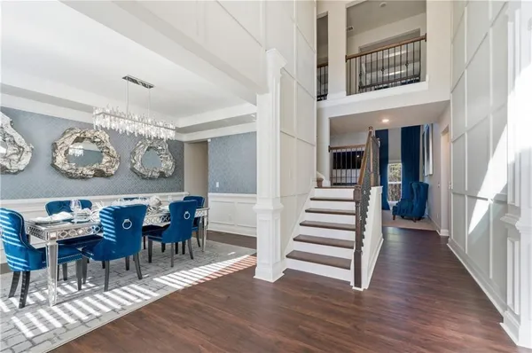 a view of a hallway with dining room and wooden floor