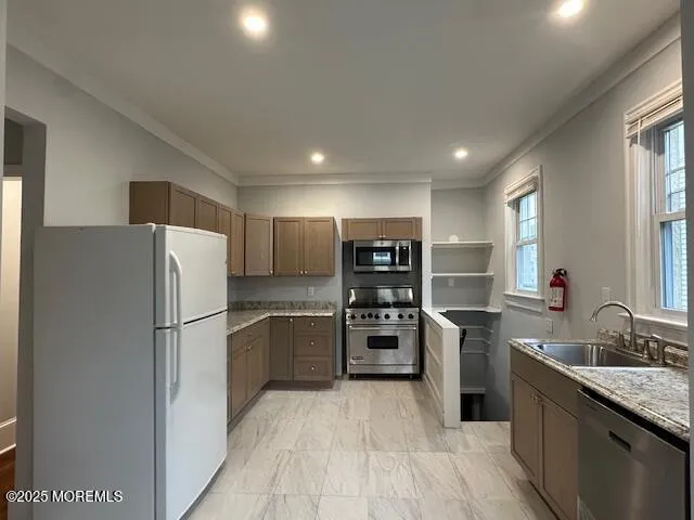 a kitchen with stainless steel appliances granite countertop a refrigerator sink and stove