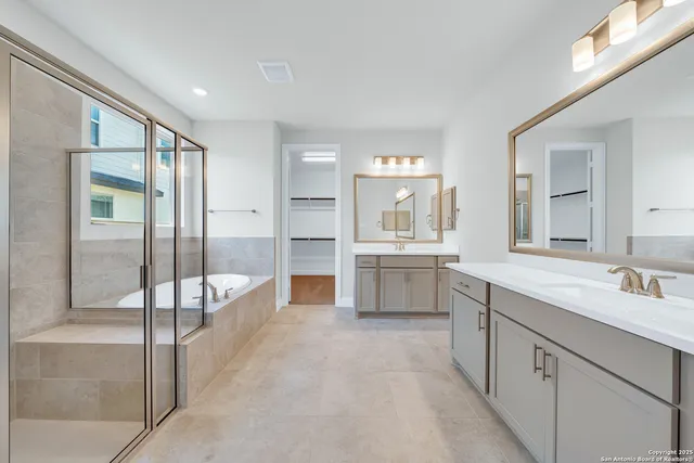 a large bathroom with a large mirror vanity and shower