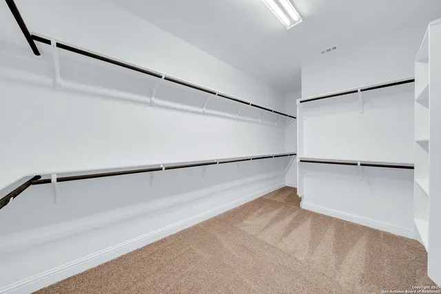 a view of walk in closet with empty racks