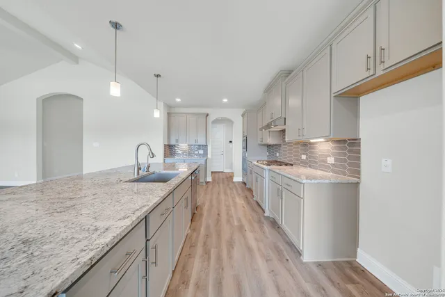 a kitchen with stainless steel appliances granite countertop a sink stove and cabinets