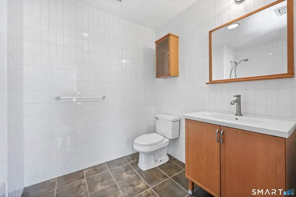 a bathroom with a toilet sink and mirror