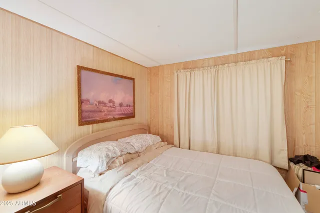 a bedroom with a bed and a painting on the wall