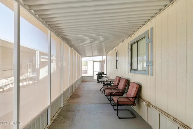 a hallway with chairs and couches with wooden floor
