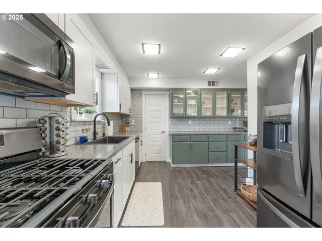 a kitchen with a sink stainless steel appliances and cabinets