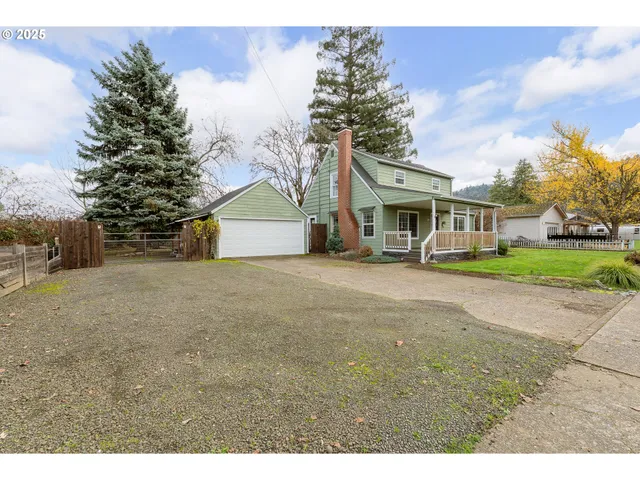a view of house with outdoor space and tree in the background
