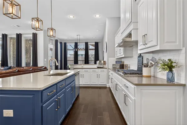 a large kitchen with stainless steel appliances granite countertop a lot of counter space and wooden floors