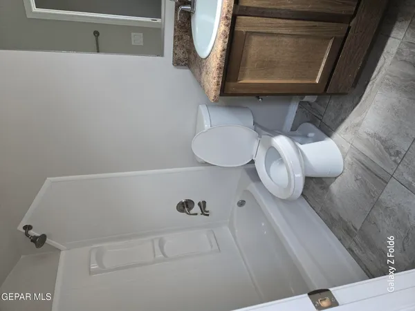 a bathroom with a toilet mirror and vanity
