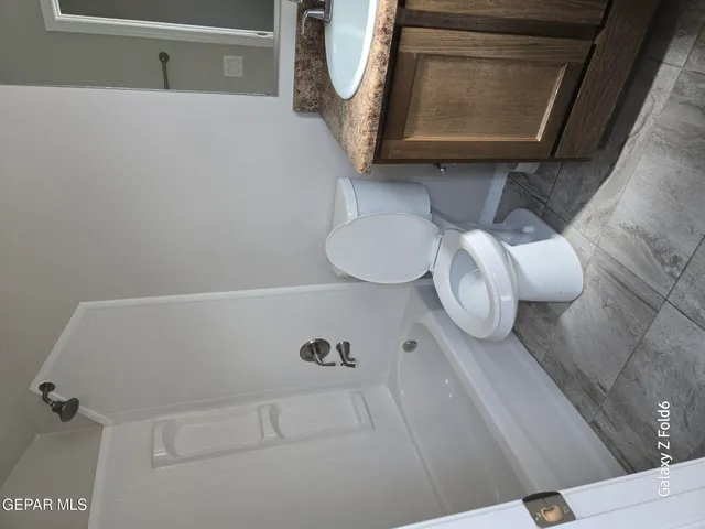 a bathroom with a toilet mirror and vanity