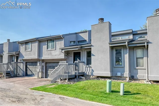 a view of a house with a yard and a large tree