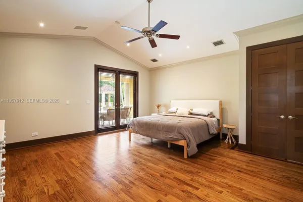 a spacious bedroom with a bed and a ceiling fan